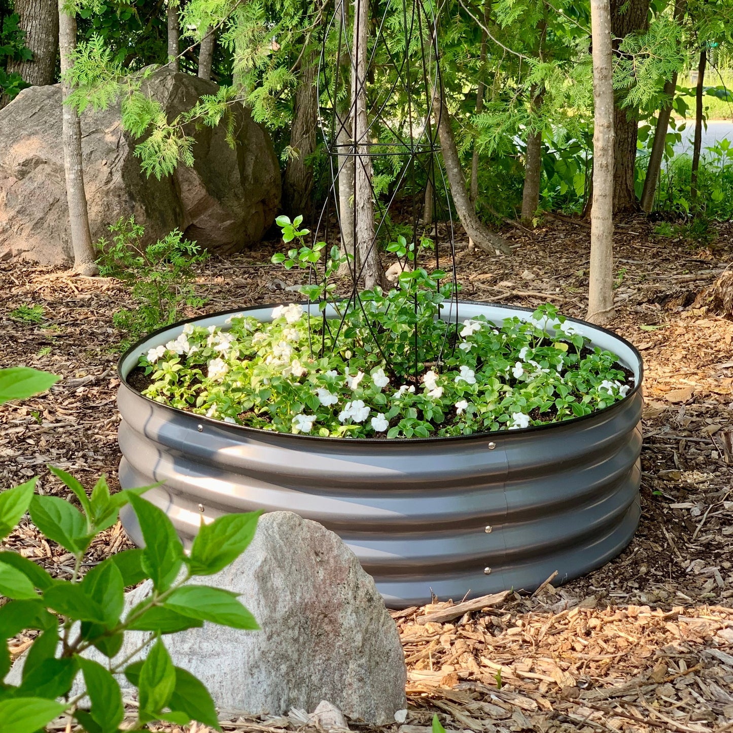 Tall Round raised garden bed planted with flowers in Canada