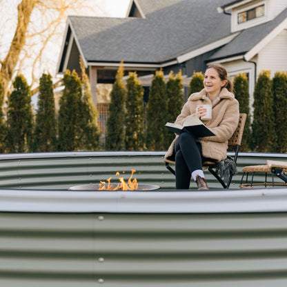 woman sitting in 17" nest garden bed in front of fire in backyard in Canada